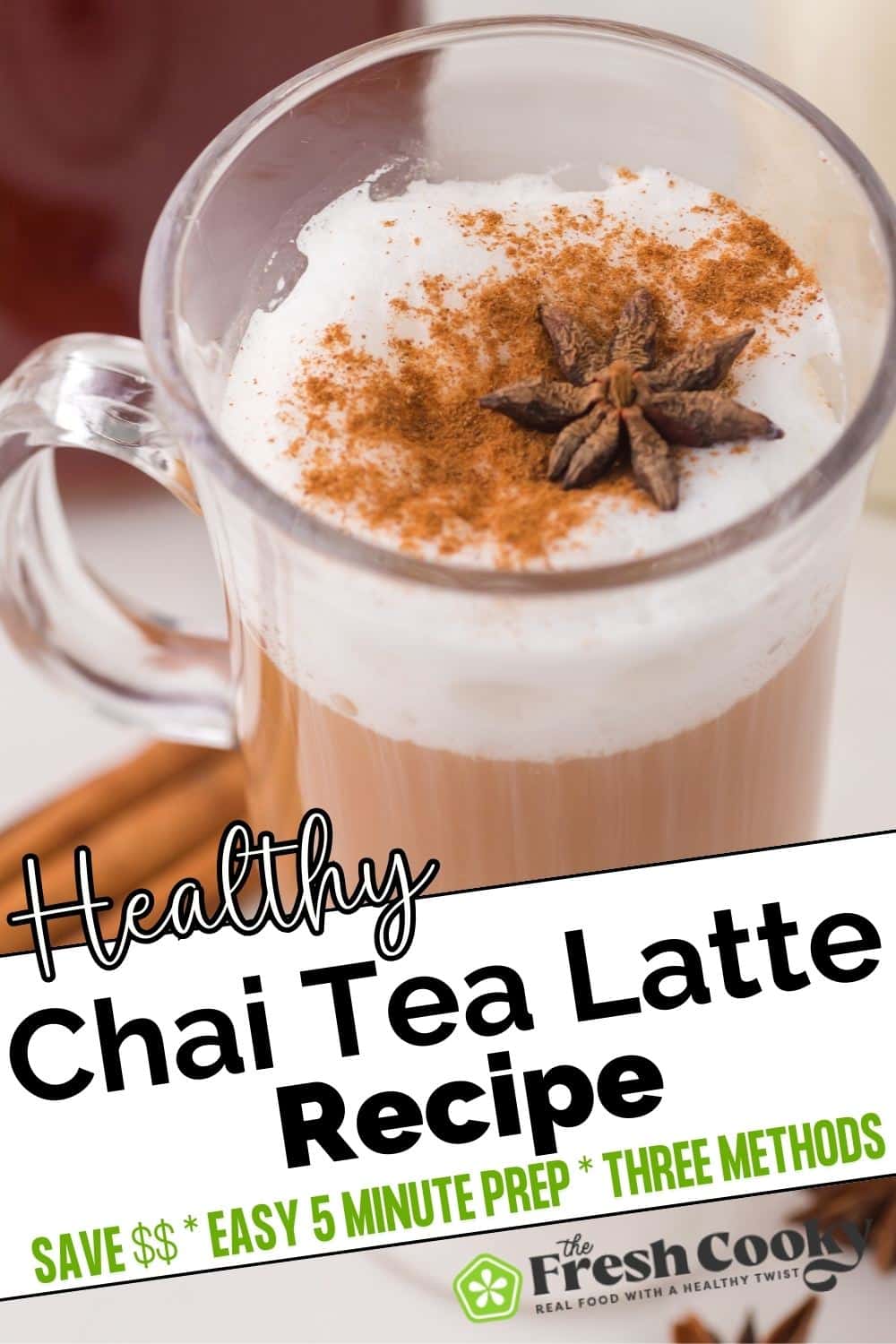 A hot chai tea latte in a glass mug with foamy milk on top dusted with cinnamon and a star anise. 