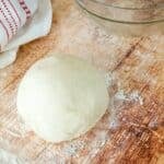Easy and Quick Pizza Dough Recipe with dough on floured surface square.