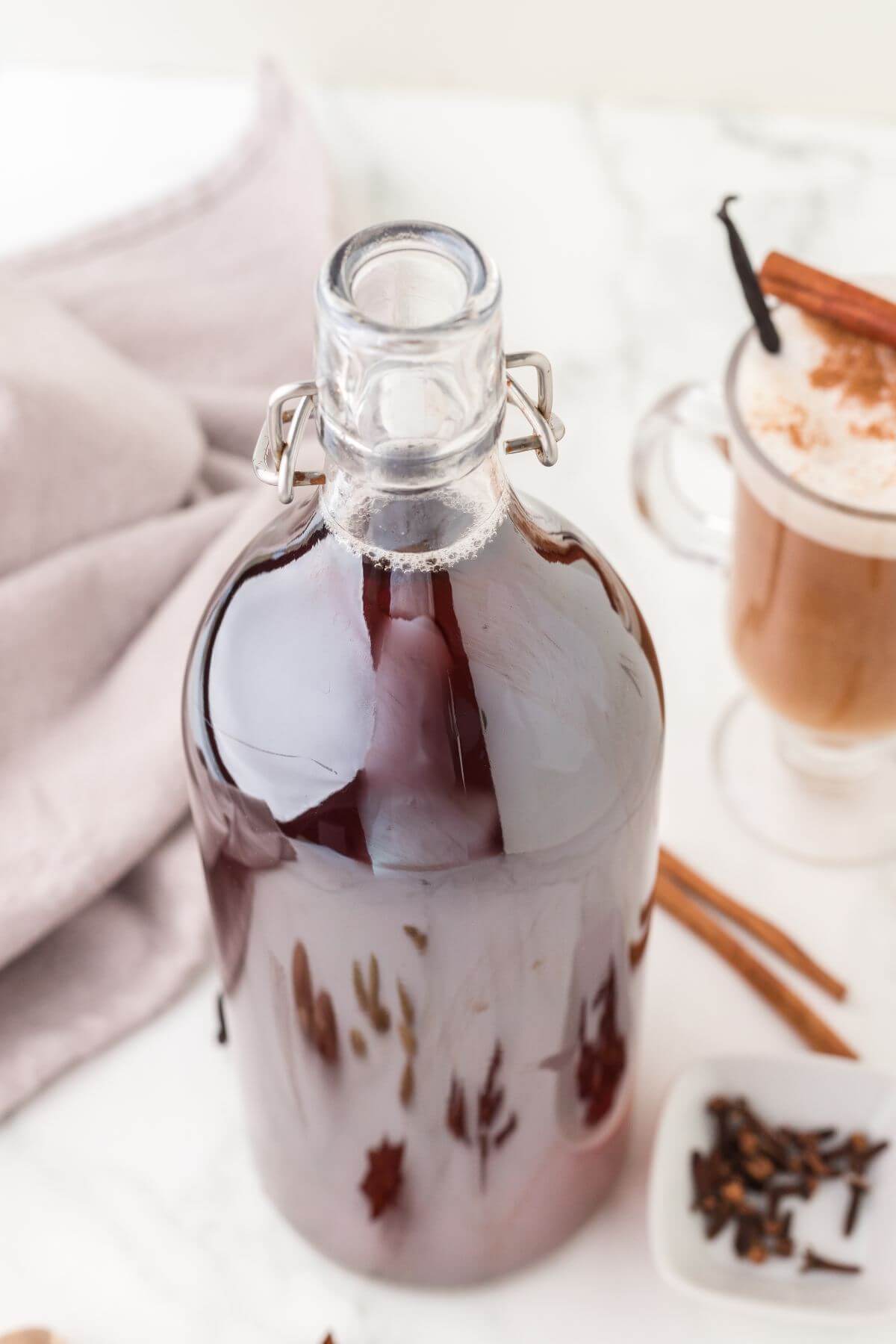 Swing top bottle filled with dark brown chai concentrate liquid. 