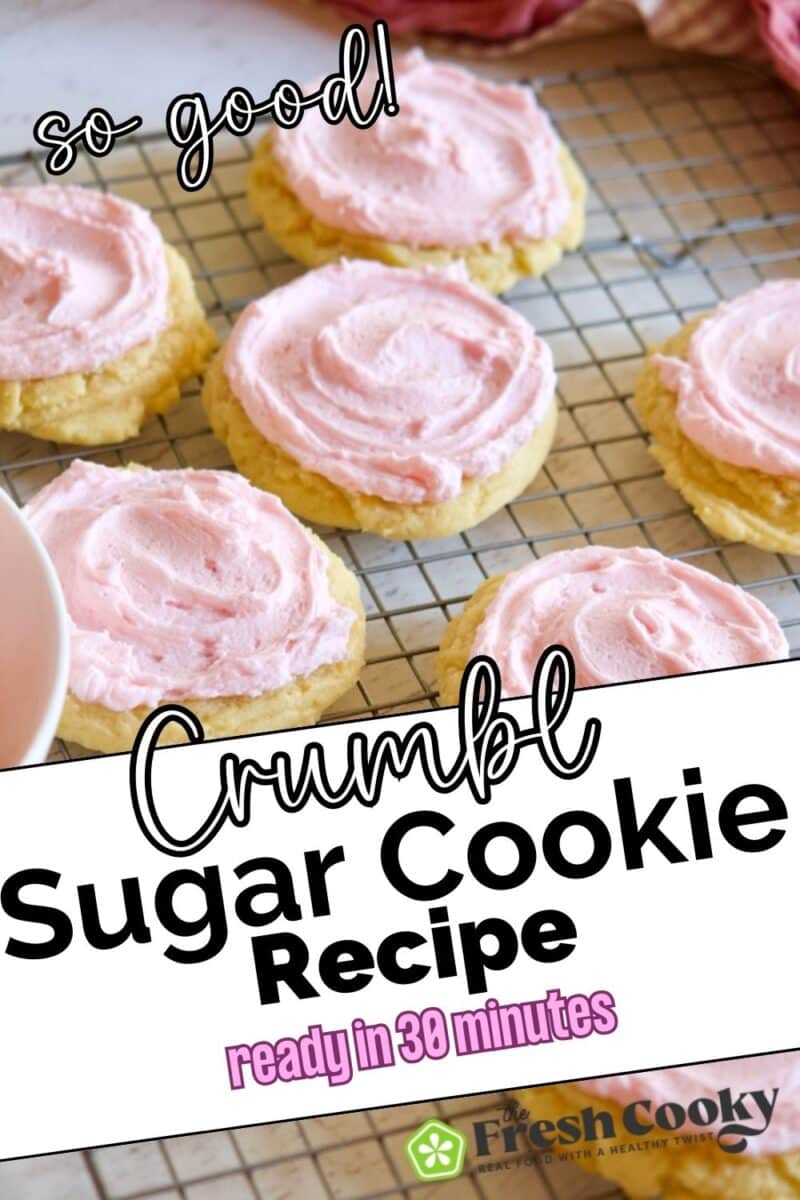 Multiple thick and chewy sugar cookies with pink frosting on a cooling rack, to pin.