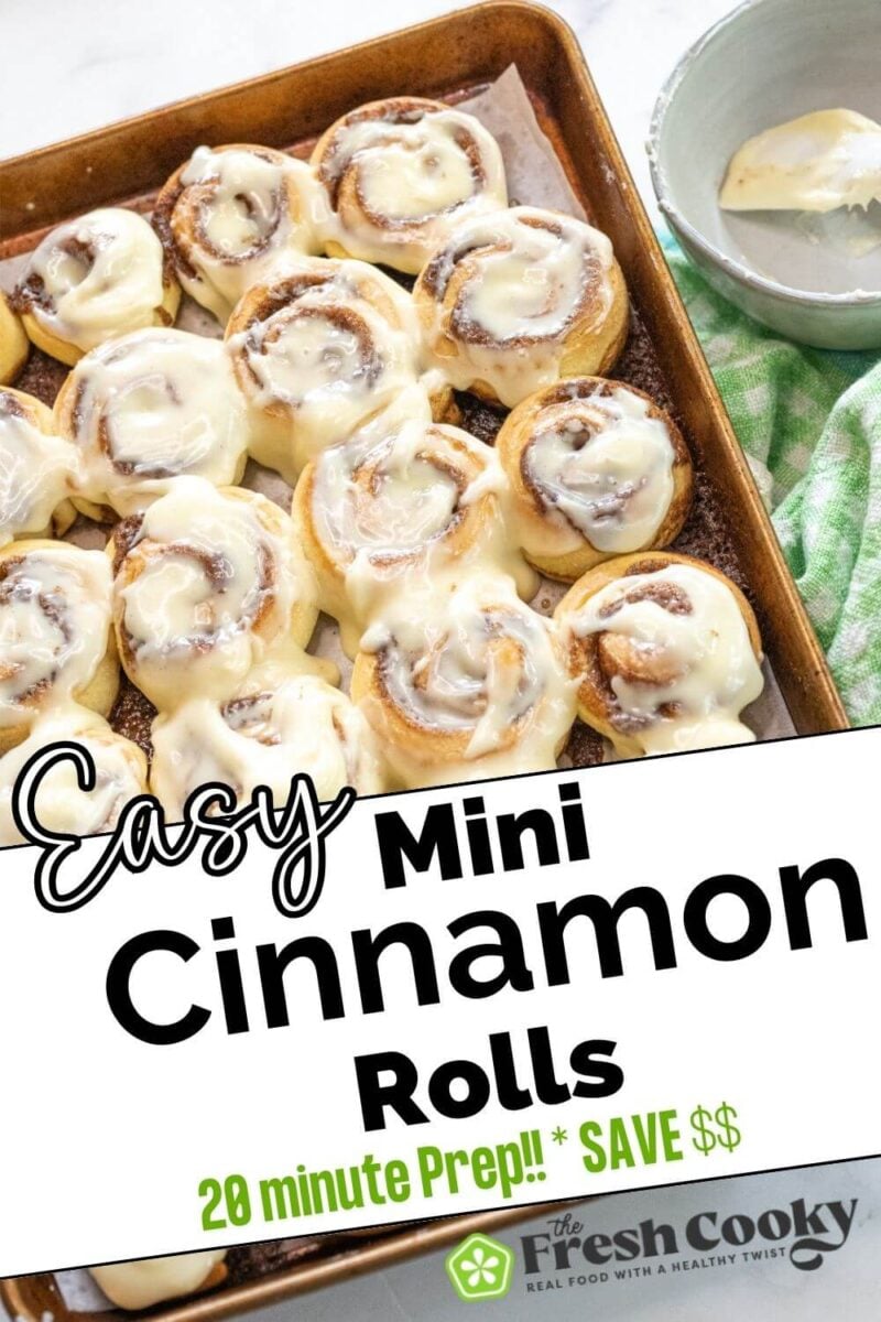 A metal pan full of cinnamon rolls has a full coating of icing on top, to pin.